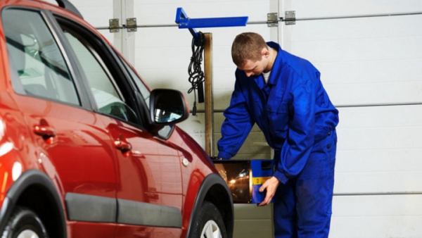 An inspector checks a car at a technical inspection point.
